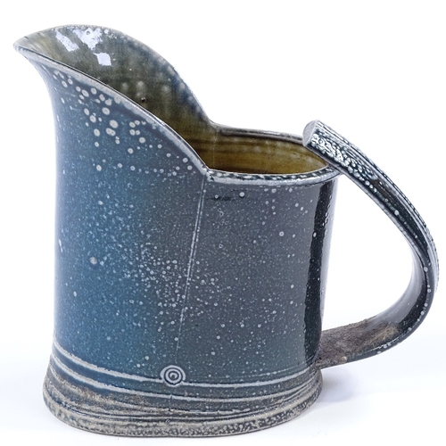 65 - Walter Keeler (British born 1942), a blue salt glaze leaning jug, height 18cm, hairline crack