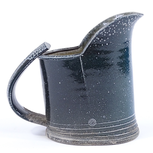 65 - Walter Keeler (British born 1942), a blue salt glaze leaning jug, height 18cm, hairline crack