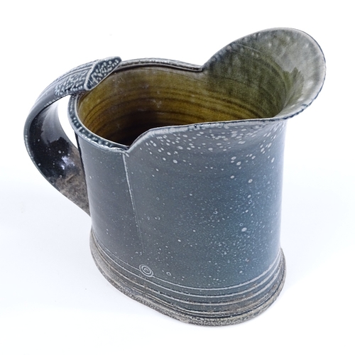 65 - Walter Keeler (British born 1942), a blue salt glaze leaning jug, height 18cm, hairline crack