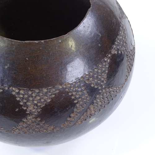 108 - A Tribal black glaze terracotta bowl with incised frieze, height 17cm