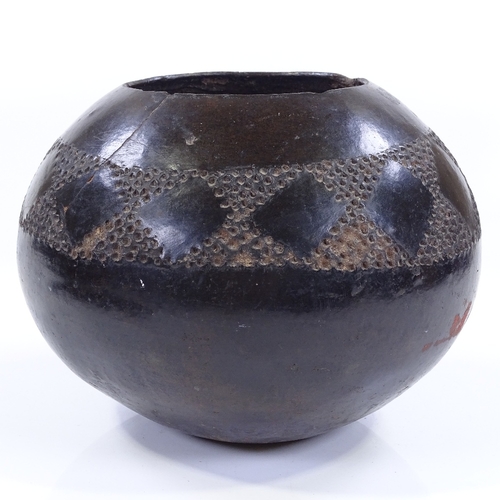 108 - A Tribal black glaze terracotta bowl with incised frieze, height 17cm