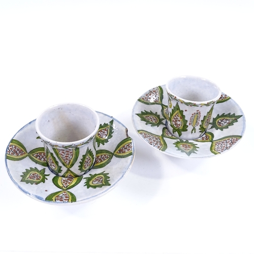 181 - A pair of Turkish pottery coffee cups and saucers, with painted decoration