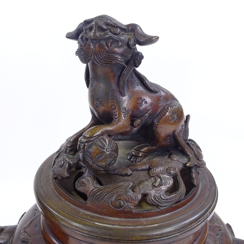 199 - A pair of Oriental patinated bronze vases and covers, with Dog of Fo knops and bird decorated relief... 