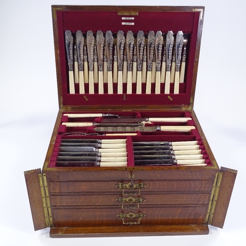 79 - A canteen of plated cutlery and servers for 12 people, with ivory handles, circa 1900, in oak cantee... 