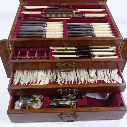 79 - A canteen of plated cutlery and servers for 12 people, with ivory handles, circa 1900, in oak cantee... 