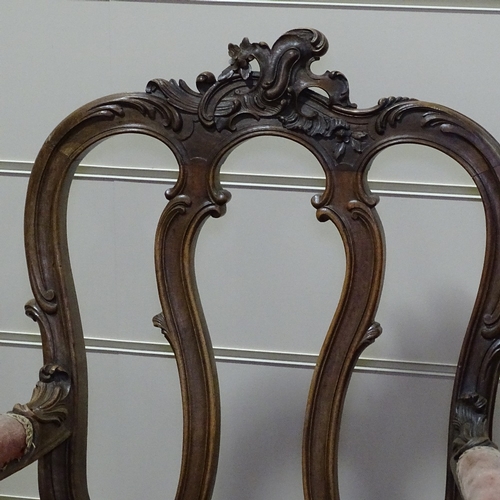 249 - A pair of 19th century walnut-framed armchairs, with all over carved decoration