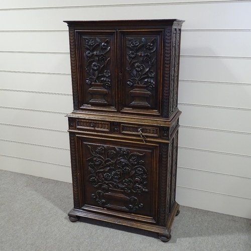 256 - An Antique Flemish oak cupboard, high relief floral carved and panelled doors, with 2 central frieze... 