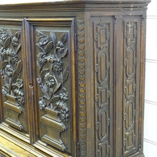 256 - An Antique Flemish oak cupboard, high relief floral carved and panelled doors, with 2 central frieze... 