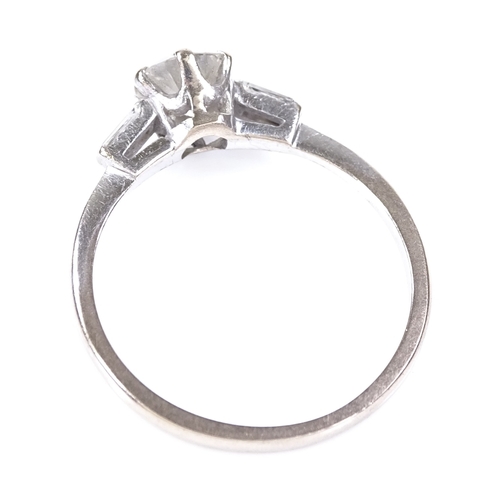 388 - A 0.7ct solitaire diamond ring, 18ct white gold settings with tapered baguette-cut diamond shoulders... 