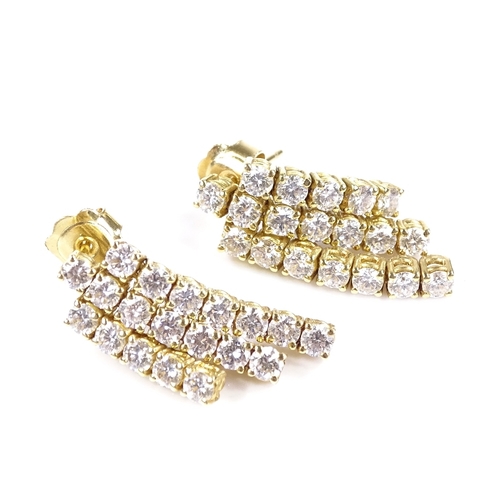 403 - A pair of unmarked gold triple-row diamond earrings, each set with 19 round brilliant-cut diamonds, ... 