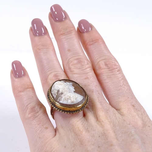 428 - An unmarked gold large relief carved cameo panel ring, depicting Classical man with mask, within a r... 