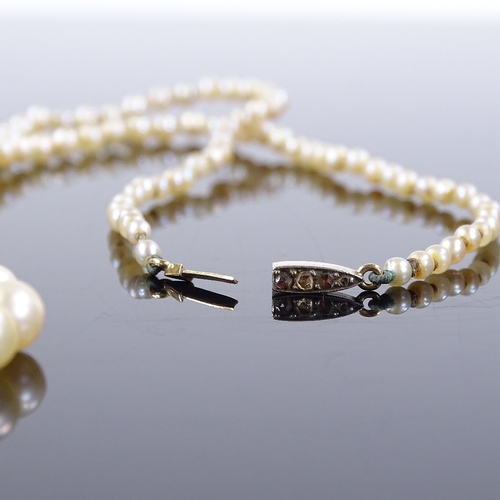 457 - A graduated single strand matinee pearl necklace, with unmarked gold rose-cut diamond set clasp, lar... 