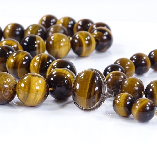 502 - A suite of polished tiger's eye bead jewellery, including necklace, bracelet, earrings and ring, nec... 