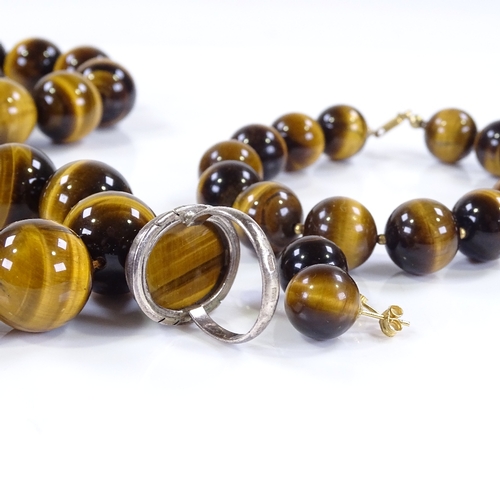 502 - A suite of polished tiger's eye bead jewellery, including necklace, bracelet, earrings and ring, nec... 