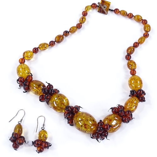 504 - An amber bead necklace, together with a matching pair of earrings (2)