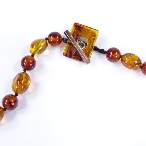 504 - An amber bead necklace, together with a matching pair of earrings (2)