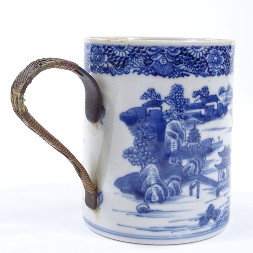 58 - An 18th century blue and white porcelain mug with hand painted decoration and wicker covered metal h... 