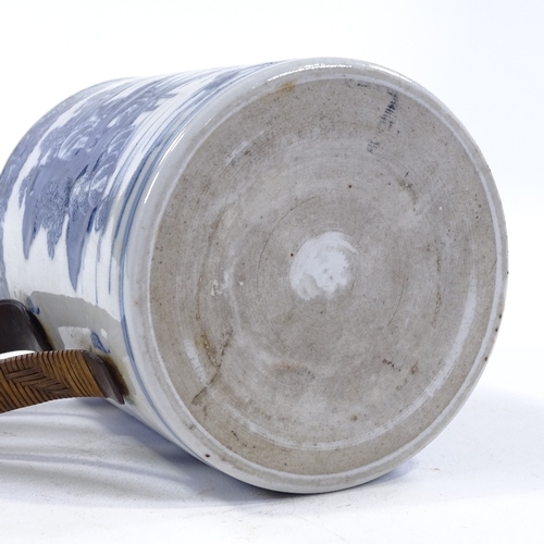 58 - An 18th century blue and white porcelain mug with hand painted decoration and wicker covered metal h... 