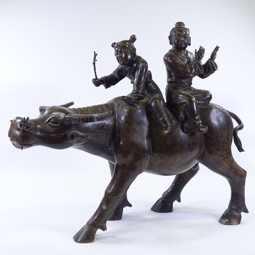 64 - WITHDRAWN A large Chinese patinated bronze sculpture of 2 children riding a water buffalo, height 58... 