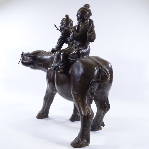 64 - WITHDRAWN A large Chinese patinated bronze sculpture of 2 children riding a water buffalo, height 58... 