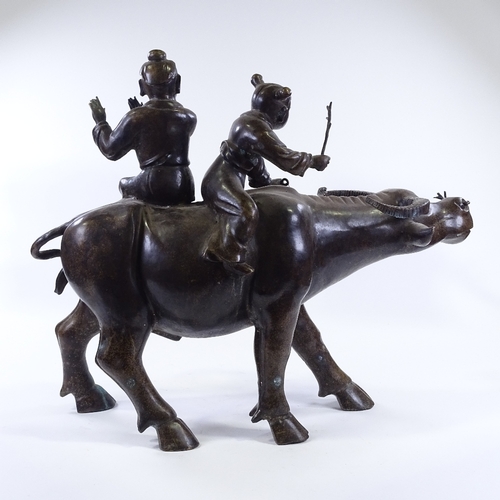 64 - WITHDRAWN A large Chinese patinated bronze sculpture of 2 children riding a water buffalo, height 58... 