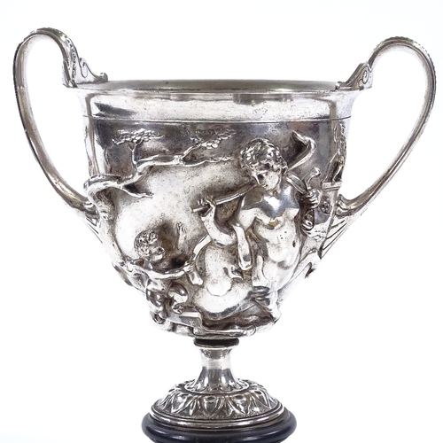 74 - A 19th century electroplate 2-handled cup, decorated with Classical figures in high relief, on circu... 