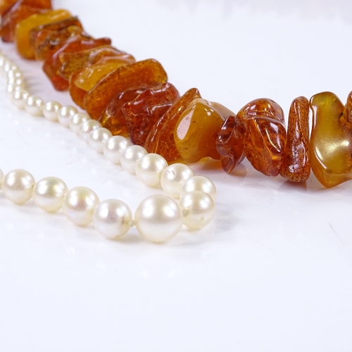 817 - A graduated single-strand pearl necklace, together with a graduated string of Baltic amber (2)