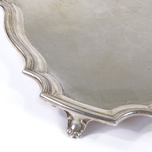 838 - A large George VI square silver tray, with scalloped edge and scrolled foliate feet, by Walker & Hal... 