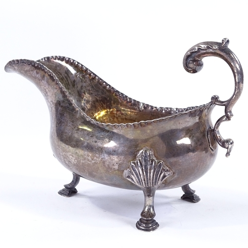 851 - A George III silver gravy boat, with scrolled acanthus C-handle and hoof feet, possibly by George Sm... 