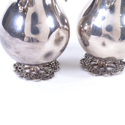 859 - A pair of Islamic silver rose water sprinklers, in the form of a pear, with cast-silver floral decor... 