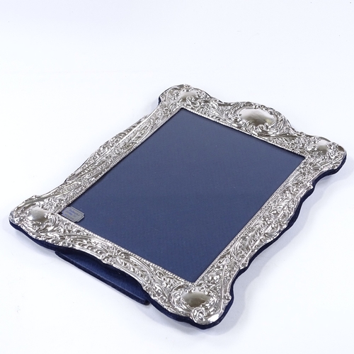 866 - A modern sterling silver-fronted photo frame, with relief embossed foliate and floral decoration, ma... 