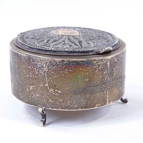 873 - An Iraqi silver circular dressing table box, with applied gold heart panel and filigree surround, di... 