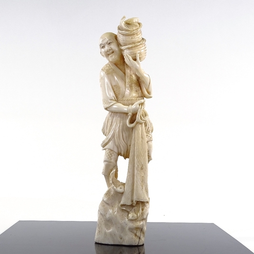 21 - A Japanese Meiji Period ivory carving of a fisherman with baskets and net, height 27cm