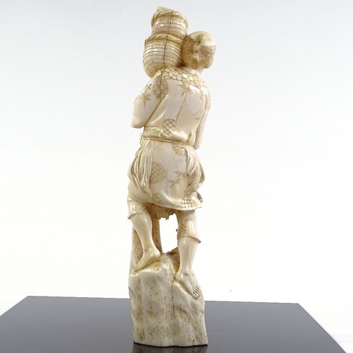 21 - A Japanese Meiji Period ivory carving of a fisherman with baskets and net, height 27cm