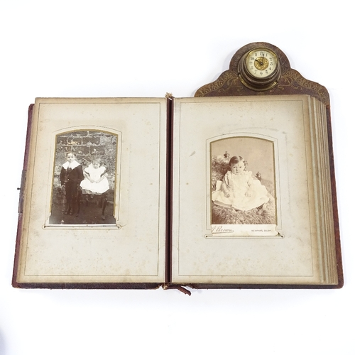 25 - A Victorian leather-bound photograph album, with brass-mounted clock set to the pediment, the front ... 