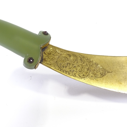 50 - An Indo-Persian curved ceremonial dagger, with engraved gilt-metal blade and carved green jade handl... 