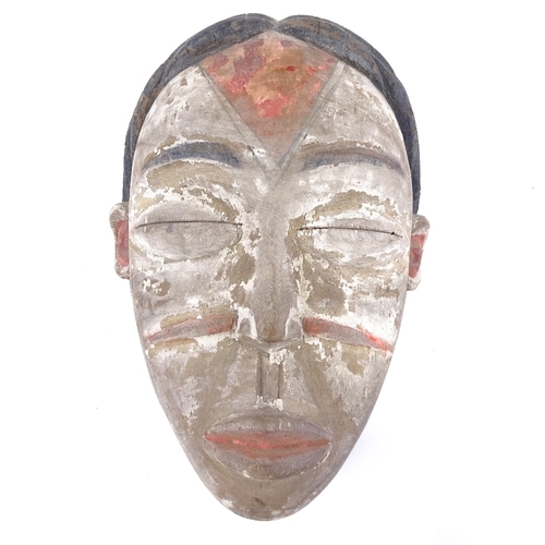 79 - A Punu carved and painted wood Tribal mask, height 21cm