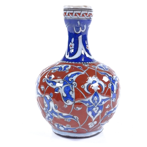 84 - A Turkish red and blue glaze narrow-necked bottle with painted enamel decoration, height 19cm