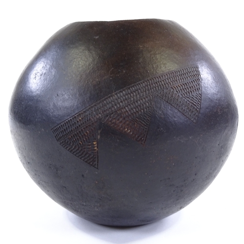 184 - A handmade African terracotta vase with incised decoration, height 23cm