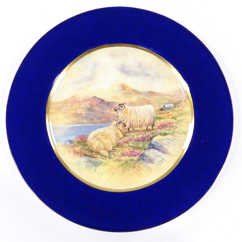 211 - A plate with hand painted scene depicting sheep in a landscape, signed Francis Clark, diameter 27cm