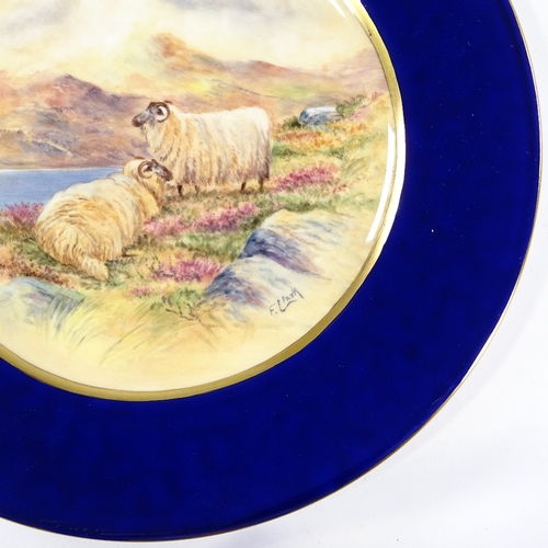 211 - A plate with hand painted scene depicting sheep in a landscape, signed Francis Clark, diameter 27cm