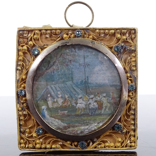 212 - A 19th century Indian miniature watercolour depicting an encampment, in ornate jewel set gilt-metal ... 