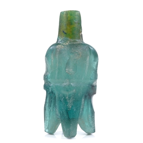 219 - A Fatimid green glass molar design flask, length 6.5cm