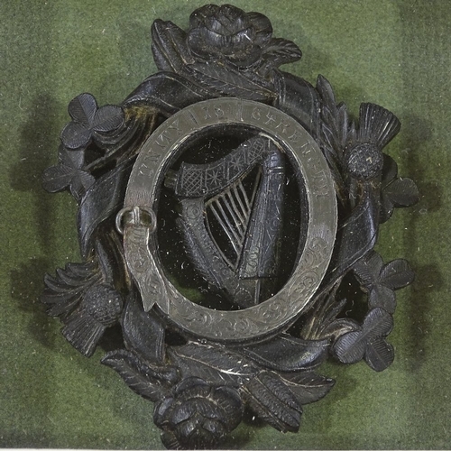 235 - A Victorian carved bog oak Unity badge, with silver mount and shamrock rose and thistle designs, len... 