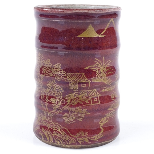 284 - A Chinese red glaze porcelain brush pot with hand painted gilded landscape design, gold painted 4 ch... 