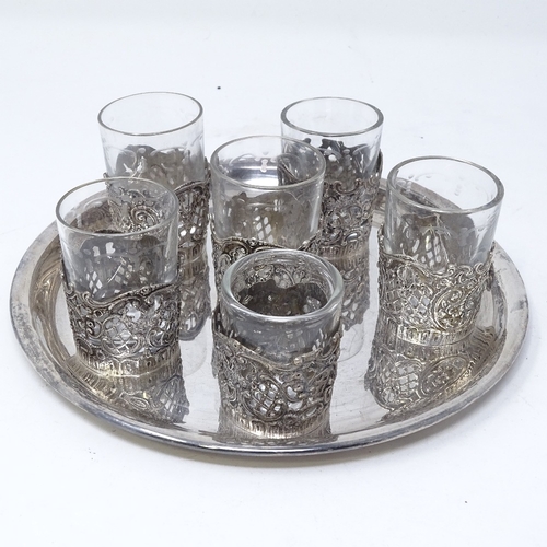 817 - A German silver drinking tot set, comprising 6 silver-mounted glass tots and circular silver tray, t... 