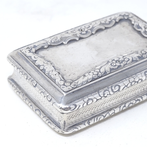 822 - A William IV rectangular silver snuffbox, with relief embossed floral decoration and engine turned b... 