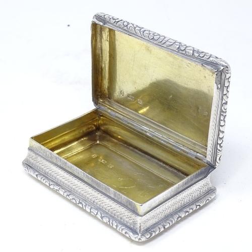 822 - A William IV rectangular silver snuffbox, with relief embossed floral decoration and engine turned b... 