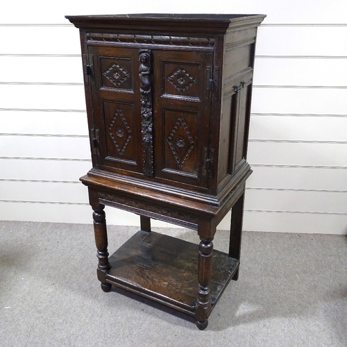 339 - An Antique carved and panelled oak 2-door cupboard on stand, 33.5