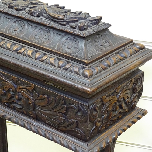 346 - A Victorian carved oak sewing box on stand with high relief carved decoration, on lion mask feet, wi... 